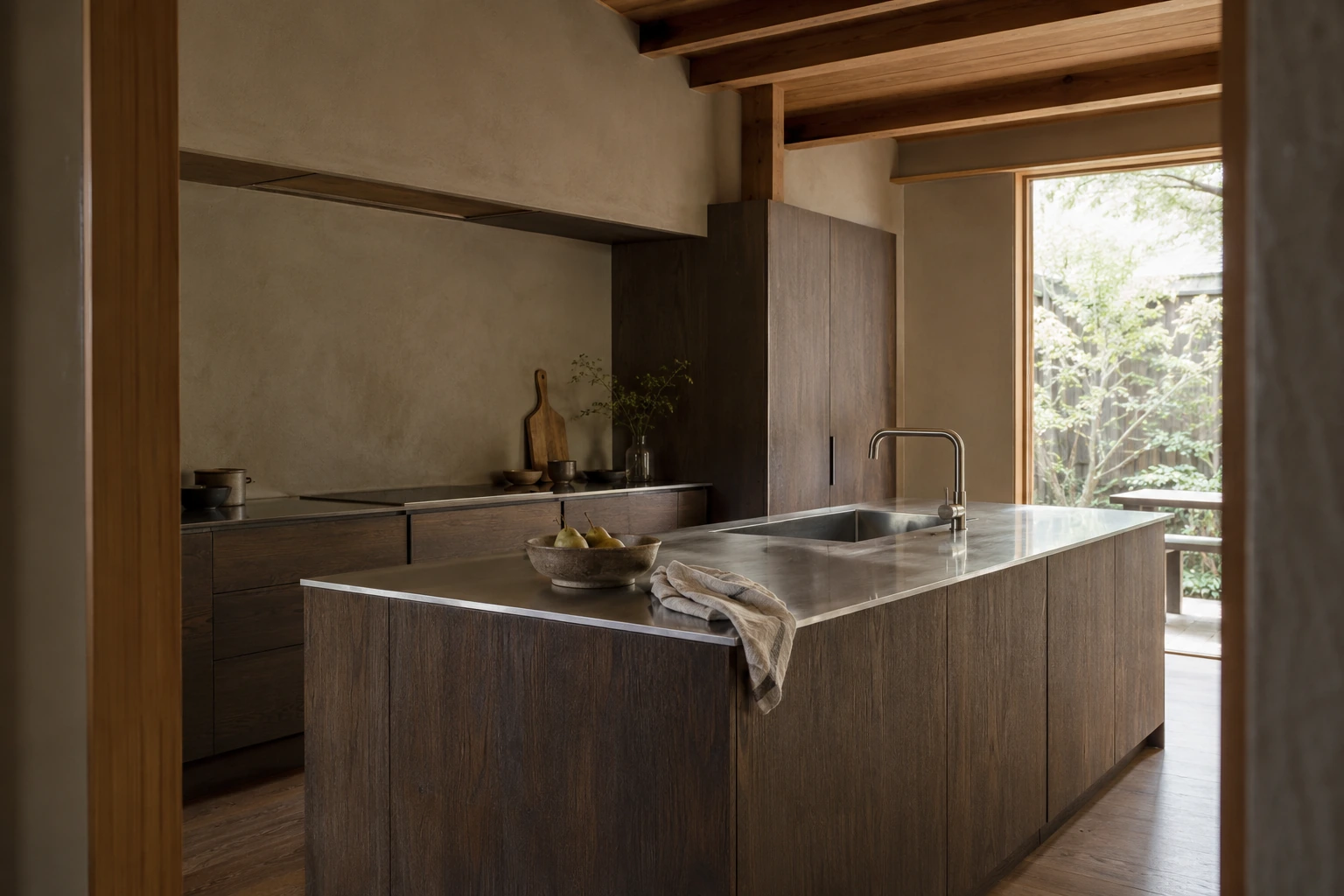 Smoked-oak Japanese kitchen with brushed steel surfaces and soft garden light